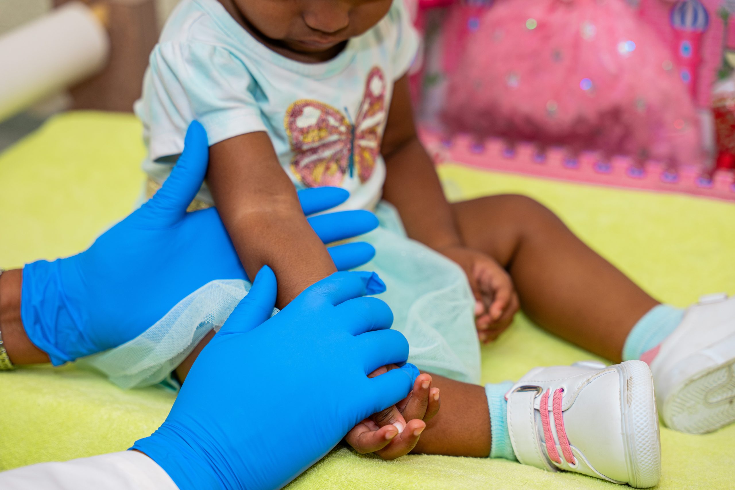 Employee of Medical Laboratory Services Curaçao taking extra steps to assist in getting a test sample from a child.